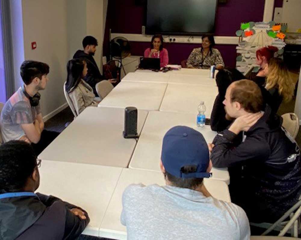 A group of young people, mixed ages, genders and races listening to a talk from West Midlands Police.
