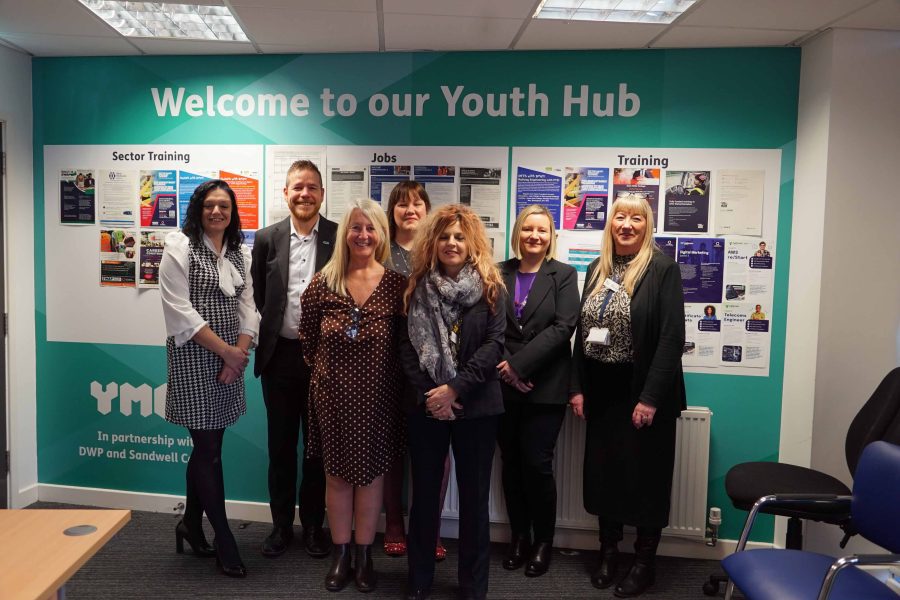 Sandwell Youth Hub workers smiling in a row looking at camera.