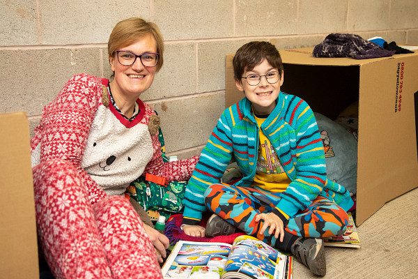Mother and son sat in onesies in a cardboard box at YMCA Sleep Easy