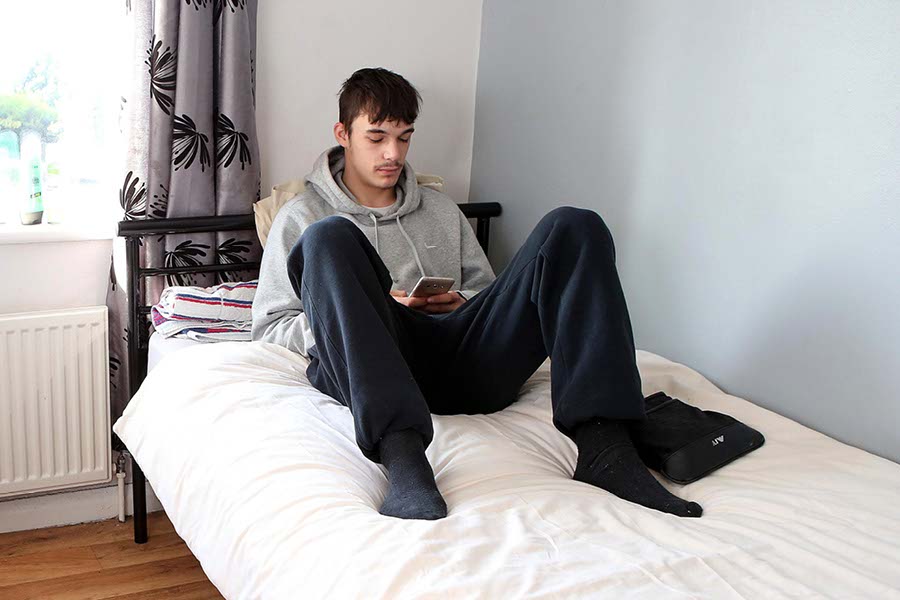 young man relaxing in bedroom at YMCA housing