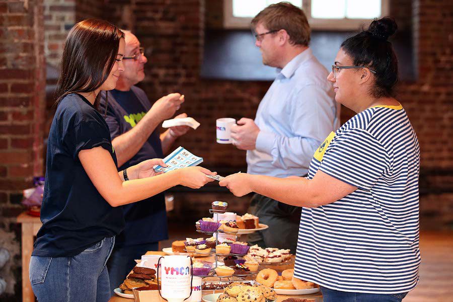 volunteers selling cakes at ymca fundraising event