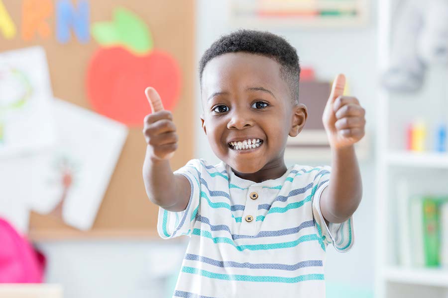 happy young boy with thumbs up at YMCA day care